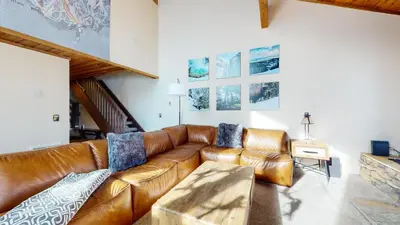a living room with a brown leather couch at Val D'Isere #35 Condo in Mammoth Lakes