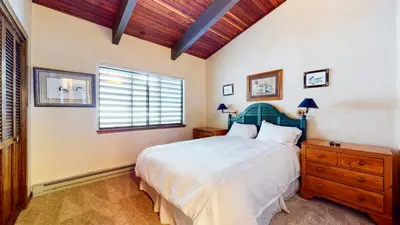 a bedroom with a large bed and a window at Mammoth West #143 Condo in Mammoth Lakes