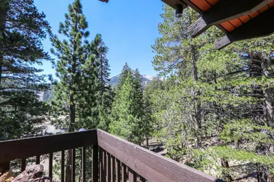 a wooden deck with a view of the trees at Mammoth West #143 Condo in Mammoth Lakes