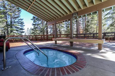 a hot tub on a patio with a bench at Hidden Valley #15 Condo in Mammoth Lakes