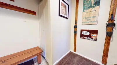 a hallway with a bench and pictures on the wall at Chateau de Montagne #29 Condo in Mammoth Lakes