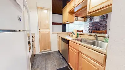 a kitchen with a sink and a refrigerator at Sierra Manors #75 Condo in Mammoth Lakes