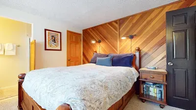 a bedroom with a large bed with a wooden headboard at Sierra Manors #75 Condo in Mammoth Lakes
