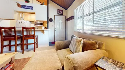 a living room with a couch and a kitchen at Sierra Manors #75 Condo in Mammoth Lakes