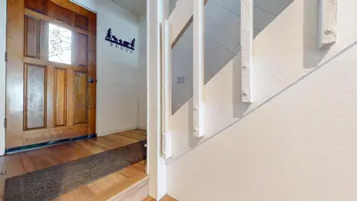 a hallway with a wooden door and a staircase at Snowcreek I #82 Condo in Mammoth Lakes