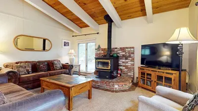 a living room with a fireplace and a television at Chateau De Montagne #24 Condo in Mammoth Lakes