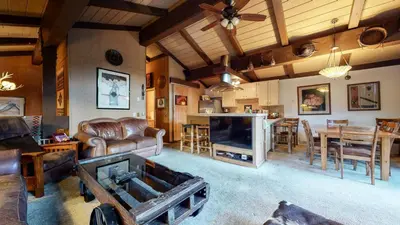 a large living room with a couch and a tv at Condo de los Pinos #16 in Mammoth Lakes