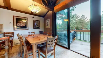a dining room with a wooden table and a balcony at Condo de los Pinos #16 in Mammoth Lakes