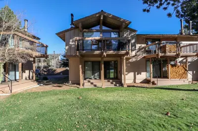 a house with a large yard in front of it at Condo de los Pinos #16 in Mammoth Lakes