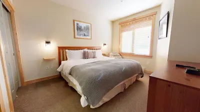 a bedroom with a large bed and a window at Sunstone #214 Condo in Mammoth Lakes