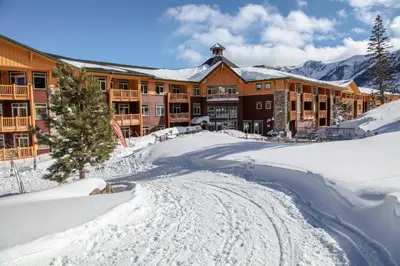 a lodge in the snow with a road in front at Sunstone #214 Condo in Mammoth Lakes