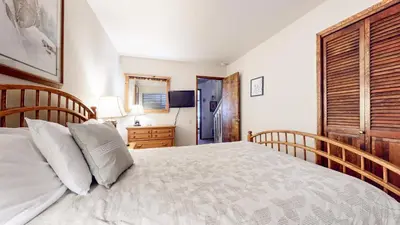 a bedroom with a large bed with a wooden headboard at Mammoth West #106 Condo in Mammoth Lakes