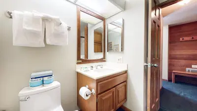 a bathroom with a toilet and a sink and a mirror at Sierra Megeve #8 Condo in Mammoth Lakes