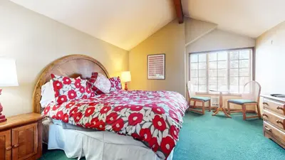 a bedroom with a bed with a red and white bedspread at Sierra Megeve #8 Condo in Mammoth Lakes