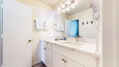 a white bathroom with a sink and a mirror at Mammoth Ski & Racquet Club #4 Condo in Mammoth Lakes
