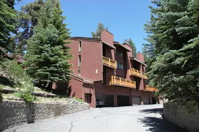 a large red building with a stone wall and trees at Mammoth Ski & Racquet Club #4 Condo in Mammoth Lakes