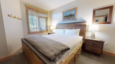 a bedroom with a large bed and a window at Sunstone #127 Condo in Mammoth Lakes