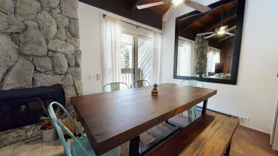 a wooden table and chairs in a room with a stone wall at Horizons 4 #150 Condo in Mammoth Lakes