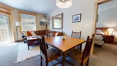 a dining room and living room with a wooden table at Sunstone #114 Condo in Mammoth Lakes