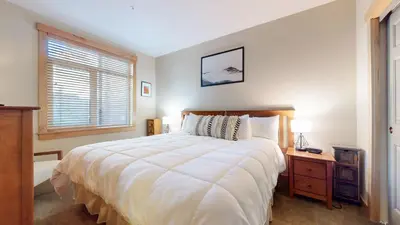 a bedroom with a large white bed and a window at Sunstone #114 Condo in Mammoth Lakes
