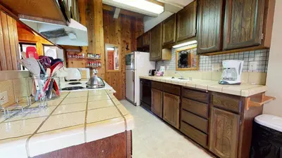 a kitchen with wooden cabinets and a refrigerator at Condo de los Pinos #30 in Mammoth Lakes