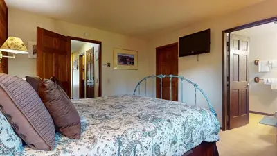 a bedroom with a bed and a flat screen tv at Snowflower #81 Condo in Mammoth Lakes