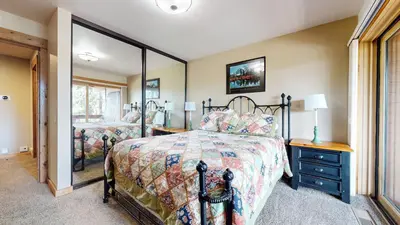 a bedroom with a bed and a large mirror at Bridges Townhome #15 Condo in Mammoth Lakes
