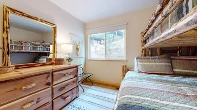 a bedroom with a bed and a dresser with a mirror at Mammoth West #115 Condo in Mammoth Lakes