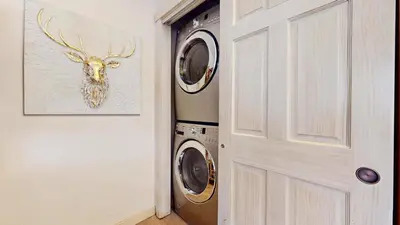 a laundry room with a washer and dryer next to a door at Mammoth West #115 Condo in Mammoth Lakes
