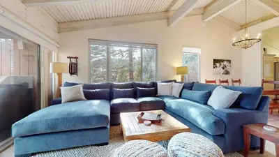 a living room with a blue couch and a table at Mammoth West #115 Condo in Mammoth Lakes