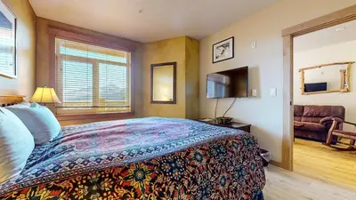 a bedroom with a bed and a window and a television at Sunstone #103 Condo in Mammoth Lakes