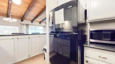 a kitchen with a black refrigerator and a microwave at Chateau De Montagne #3 Condo in Mammoth Lakes