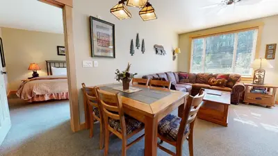 a dining room and living room with a table and chairs at Sunstone #208 Condo in Mammoth Lakes