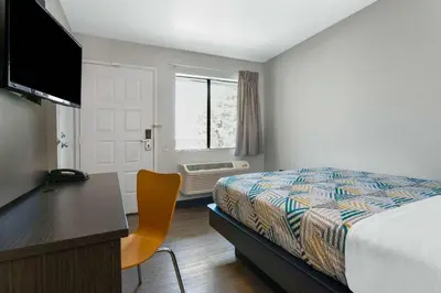 a hotel room with a bed and a desk and a window at Motel 6-Merced, CA - North in Merced