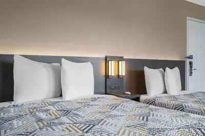 two beds with white pillows in a hotel room at Motel 6-Merced, CA - North in Merced