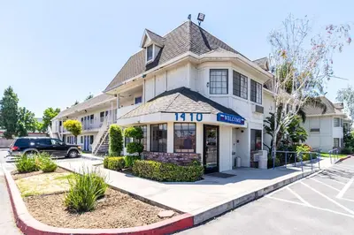 a building with a mirt store in a parking lot at Motel 6-Merced, CA - North in Merced