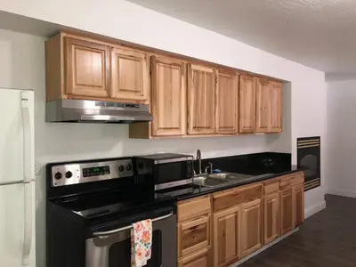 a kitchen with wooden cabinets and black appliances at Cedar Inn & Suites in South Lake Tahoe