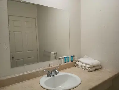 a bathroom sink with a large mirror above it at Cedar Inn & Suites in South Lake Tahoe