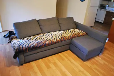 a couch with a blanket on the floor in a living room at Yosemite is Calling in Groveland
