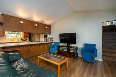 a living room with a couch and two blue chairs at Yosemite Falls Calling in Groveland