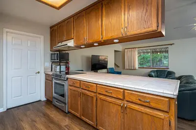 a kitchen with wooden cabinets and a counter top at Yosemite Falls Calling in Groveland