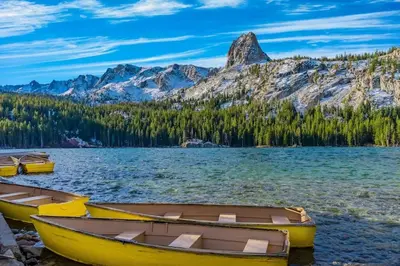 three boats on the shore of a lake with mountains at Mammoth Ski & Racquet Club #131 in Mammoth Lakes