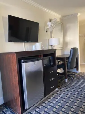 a hotel room with a flat screen tv and a desk at Budget INN At The Heavenly Gondola in South Lake Tahoe
