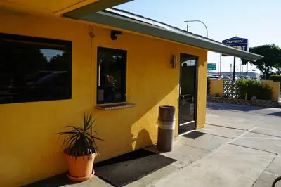 a yellow house with a potted plant in front of it at Apex Inn in Modesto