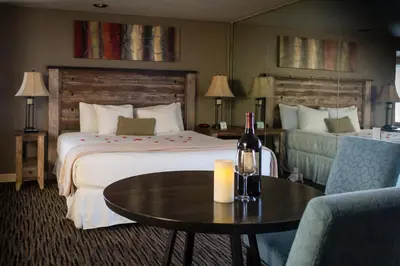 a hotel room with two beds and a table with a bottle of wine at Postmarc Hotel and Spa Suites in South Lake Tahoe