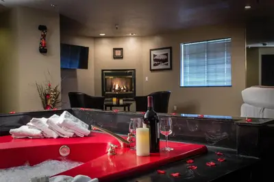 a bathroom with a red bath tub with a fireplace at Postmarc Hotel and Spa Suites in South Lake Tahoe