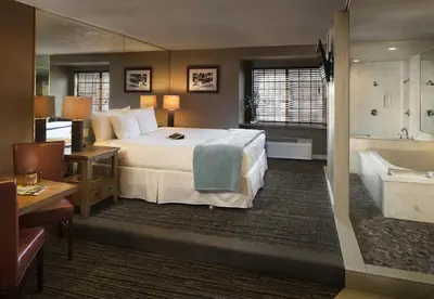 a hotel room with a bed and a bath tub at Postmarc Hotel and Spa Suites in South Lake Tahoe