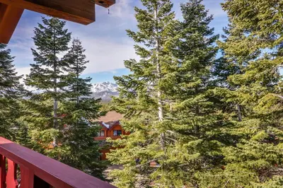 a view from the deck of a house through the trees at House on Cold Creek in South Lake Tahoe