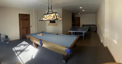 a pool table in a living room with a ping pong ball at House on Cold Creek in South Lake Tahoe