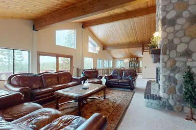 a living room with leather furniture and a stone wall at House on Cold Creek in South Lake Tahoe